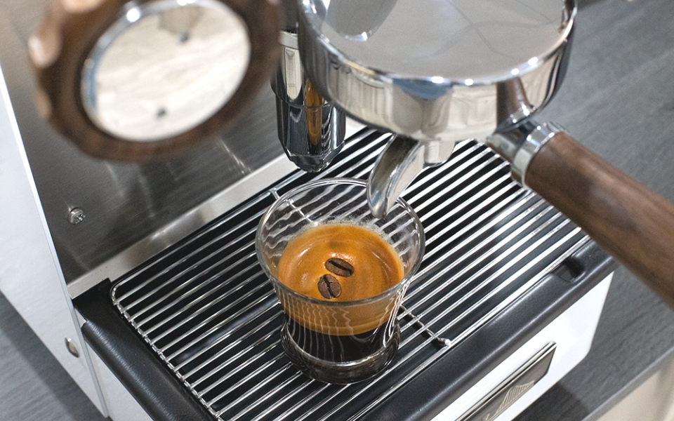 Detalle de vaso de café con café encima de la máquina de café Retro